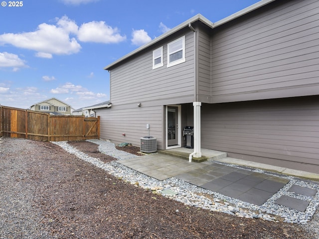 rear view of house featuring a patio area, cooling unit, and fence