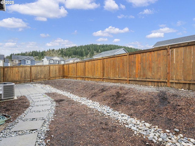 view of yard featuring a fenced backyard and central AC