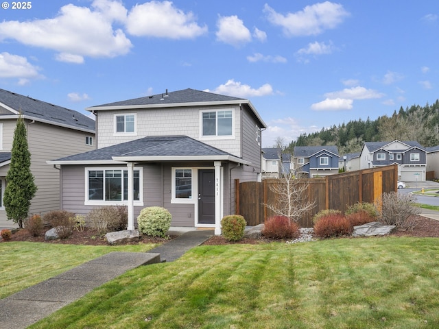 view of front of home with a front lawn and fence