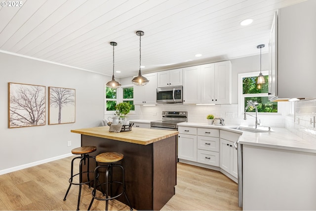 91822 Rulyville Rd, Westport, OR 97016 - kitchen featuring stainless steel appliances, wood counters, a sink, a kitchen breakfast bar, and a center island