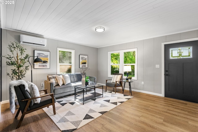 91822 Rulyville Rd, Westport, OR 97016 - living room with a wall mounted AC, light wood-style flooring, healthy amount of natural light, baseboards, and a decorative wall