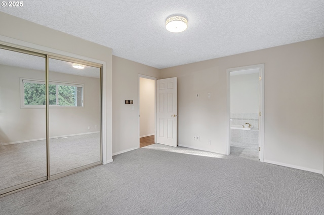 11184 S Allen Ct, Oregon City, OR 97045 - unfurnished bedroom featuring carpet flooring, a textured ceiling, a closet, and connected bathroom