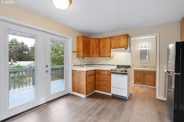 11184 S Allen Ct, Oregon City, OR 97045 - kitchen featuring freestanding refrigerator, electric stove, under cabinet range hood, brown cabinets, and light countertops