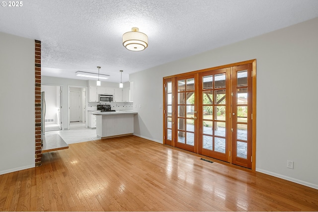 11184 S Allen Ct, Oregon City, OR 97045 - unfurnished living room with light wood finished floors and a textured ceiling
