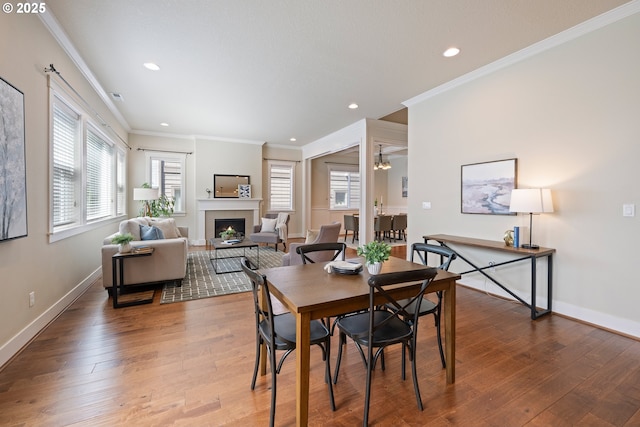 15152 NW Marie Way, Portland, OR 97229 - dining area featuring a fireplace, wood-type flooring, ornamental molding, baseboards, and recessed lighting