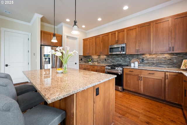 15152 NW Marie Way, Portland, OR 97229 - kitchen featuring appliances with stainless steel finishes, a breakfast bar area, light stone countertops, brown cabinets, and backsplash