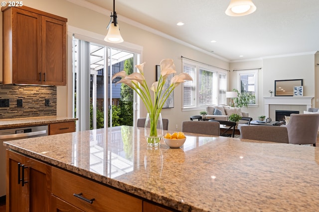 15152 NW Marie Way, Portland, OR 97229 - kitchen featuring brown cabinetry, light stone countertops, plenty of natural light, tasteful backsplash, and ornamental molding