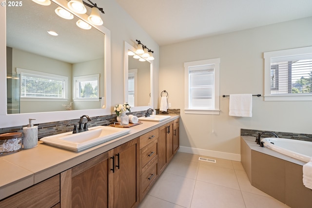 15152 NW Marie Way, Portland, OR 97229 - bathroom featuring double vanity, tile patterned floors, a garden tub, baseboards, and tasteful backsplash