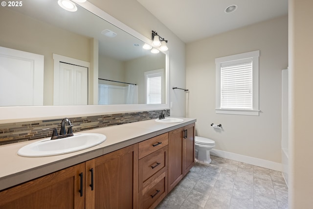 15152 NW Marie Way, Portland, OR 97229 - full bath with double vanity, baseboards, decorative backsplash, toilet, and recessed lighting