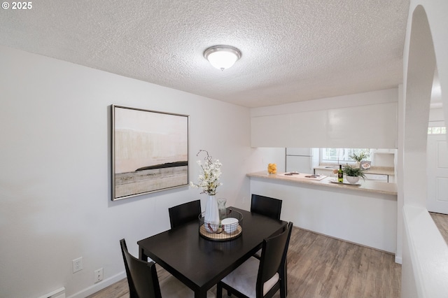 dining area featuring a textured ceiling and wood finished floors