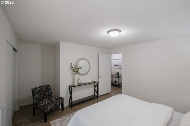 bedroom featuring a textured ceiling and wood finished floors