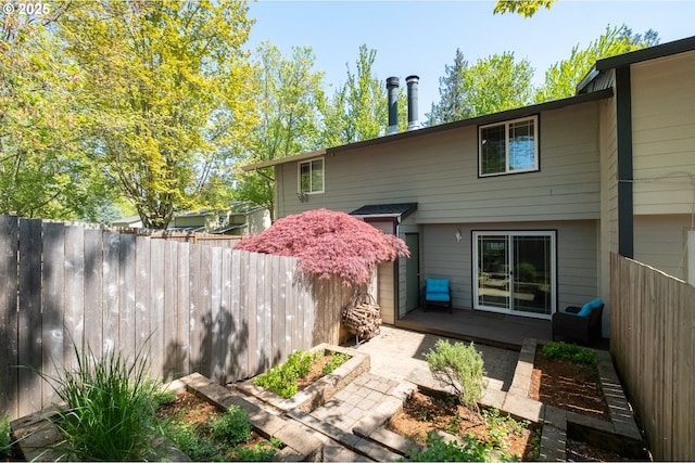 back of house with a deck and fence