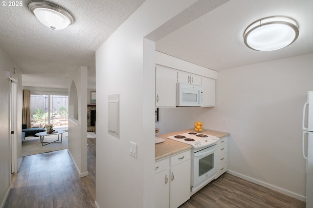 kitchen featuring light countertops, white cabinets, white appliances, and dark wood-type flooring