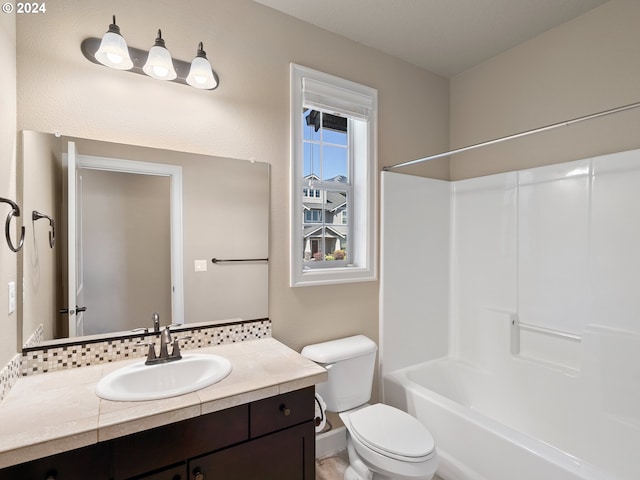 bathroom featuring toilet, tub / shower combination, and vanity