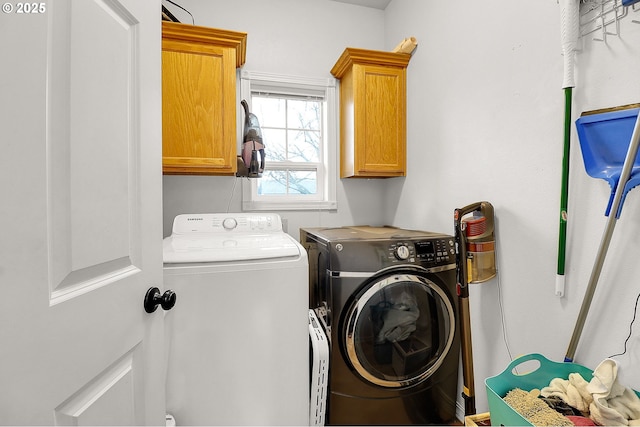 clothes washing area featuring cabinets and washing machine and dryer