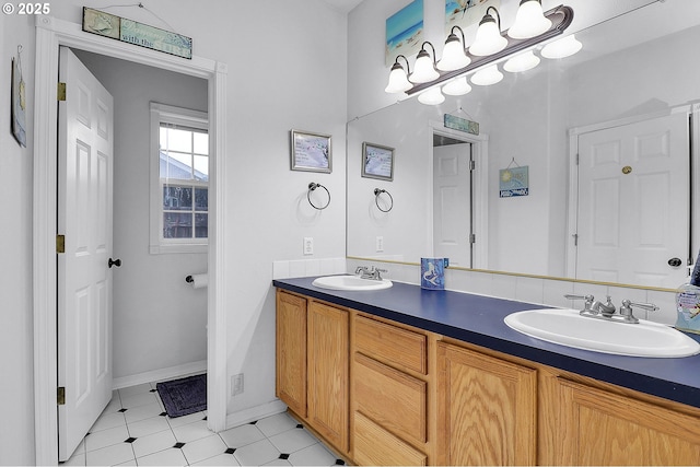 bathroom with double vanity, baseboards, and a sink