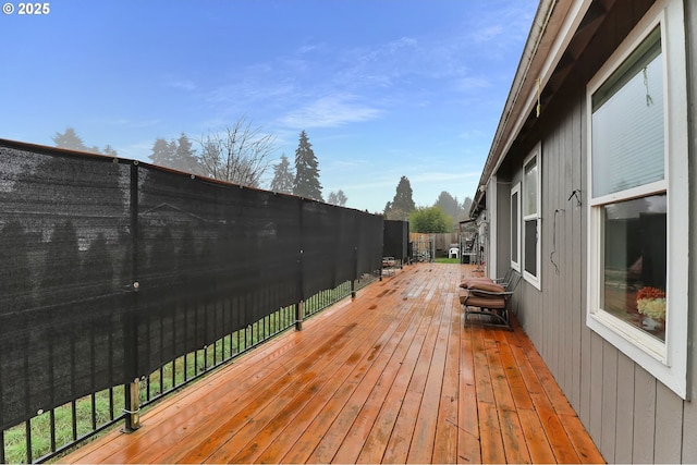 wooden terrace with a fenced backyard