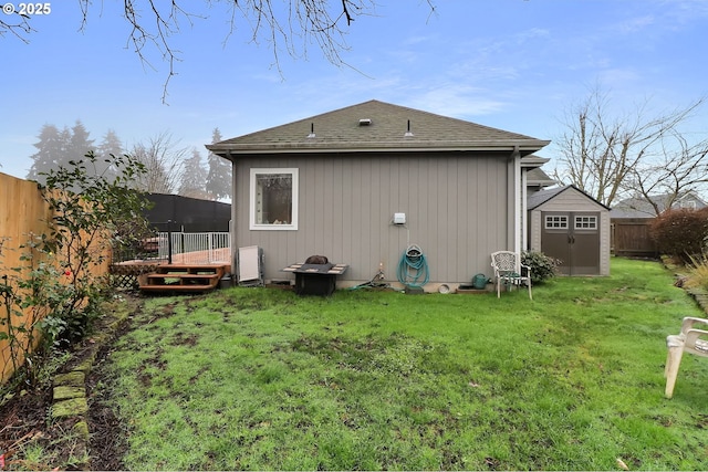 back of property featuring a storage shed, a yard, and a deck