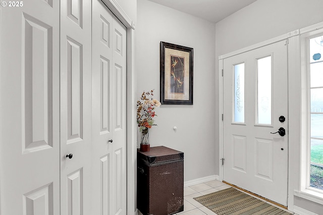 entrance foyer with light tile patterned floors and baseboards