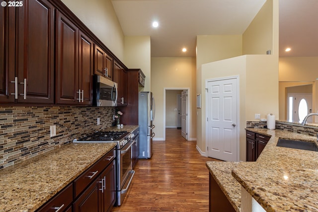 30258 King Ln, Hermiston, OR 97838 - kitchen featuring stainless steel appliances, a sink, dark wood-style floors, backsplash, and light stone countertops