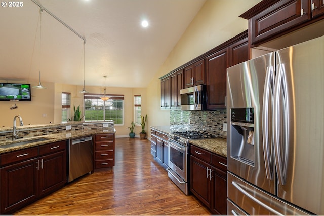 30258 King Ln, Hermiston, OR 97838 - kitchen featuring stainless steel appliances, a sink, tasteful backsplash, vaulted ceiling, and dark wood finished floors
