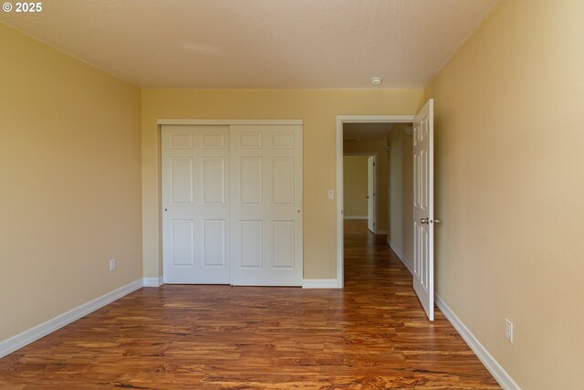 30258 King Ln, Hermiston, OR 97838 - unfurnished bedroom featuring dark wood-style floors, a closet, and baseboards