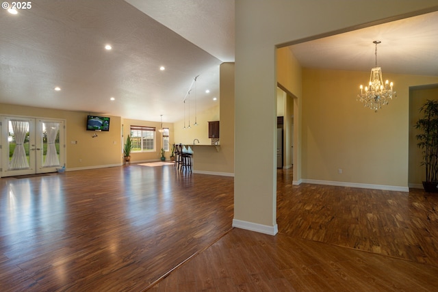 30258 King Ln, Hermiston, OR 97838 - unfurnished living room featuring a chandelier, dark wood-type flooring, recessed lighting, baseboards, and lofted ceiling