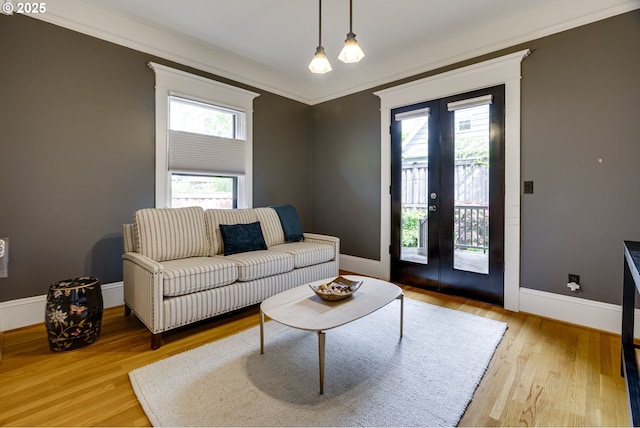 living room featuring french doors, baseboards, wood finished floors, and crown molding