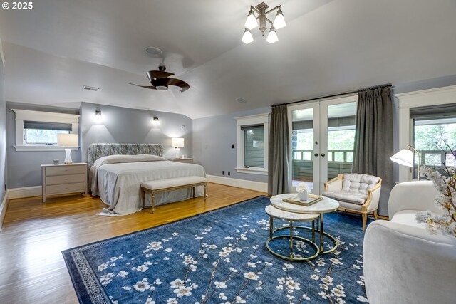 bedroom with wood finished floors, baseboards, french doors, and lofted ceiling