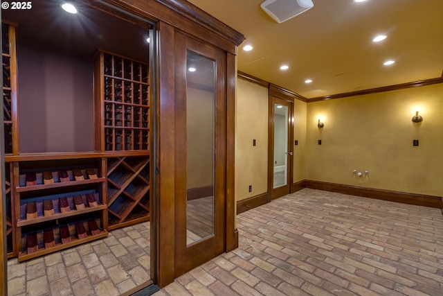 wine cellar with crown molding, baseboards, brick floors, and recessed lighting