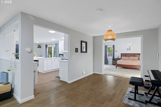 corridor featuring baseboards and dark wood-style floors