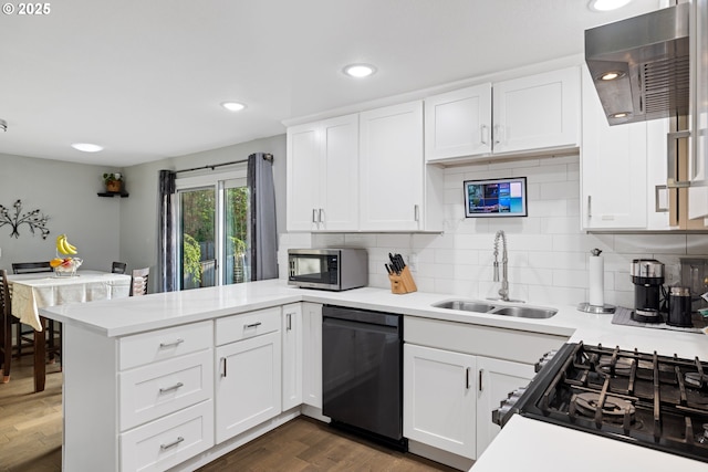 kitchen with a peninsula, black dishwasher, light countertops, stainless steel microwave, and a sink