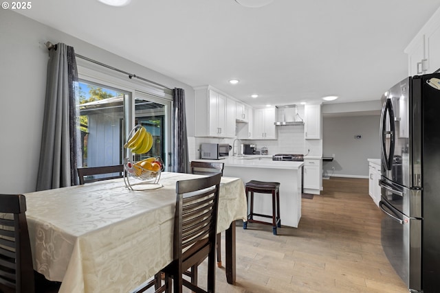 dining room featuring light wood-type flooring and recessed lighting