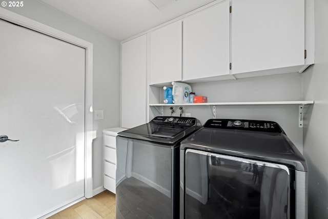 laundry room featuring cabinet space, washer and clothes dryer, and light wood-style flooring