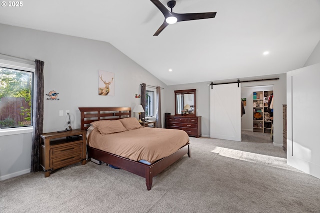 bedroom featuring multiple windows, light carpet, a barn door, and lofted ceiling