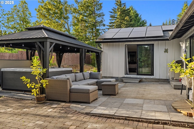 view of patio / terrace with a gazebo, outdoor lounge area, a hot tub, and fence