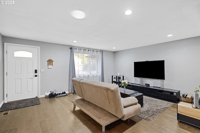 living room featuring recessed lighting, baseboards, visible vents, and wood finished floors