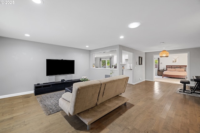 living room featuring baseboards, recessed lighting, and wood finished floors