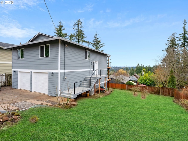 exterior space with a garage, concrete driveway, fence, and a lawn