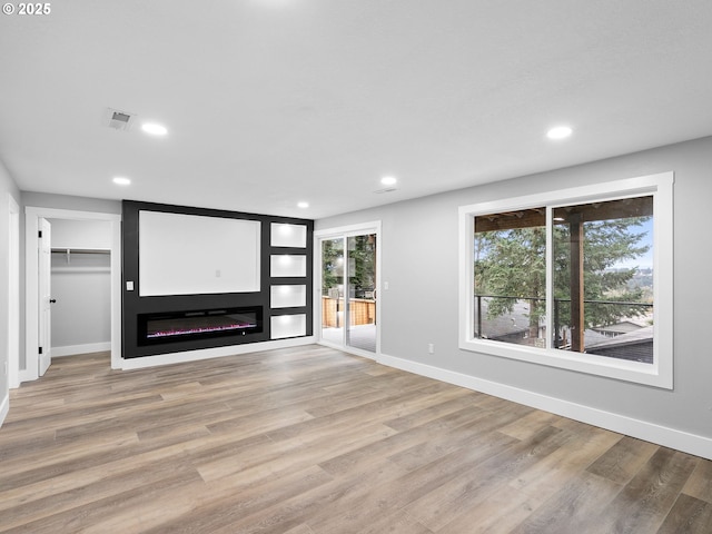 unfurnished living room with light wood-type flooring, visible vents, and recessed lighting