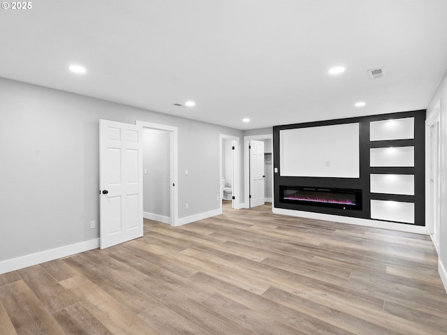 unfurnished living room with recessed lighting and light wood-style flooring