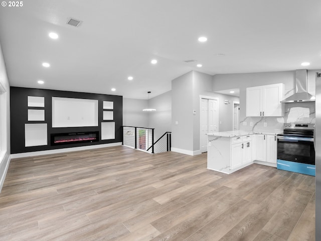 kitchen with visible vents, white cabinetry, wall chimney range hood, stainless steel electric range, and light wood finished floors