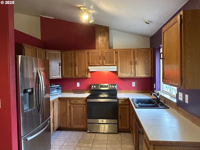 kitchen featuring stainless steel appliances, a sink, under cabinet range hood, lofted ceiling, and light countertops