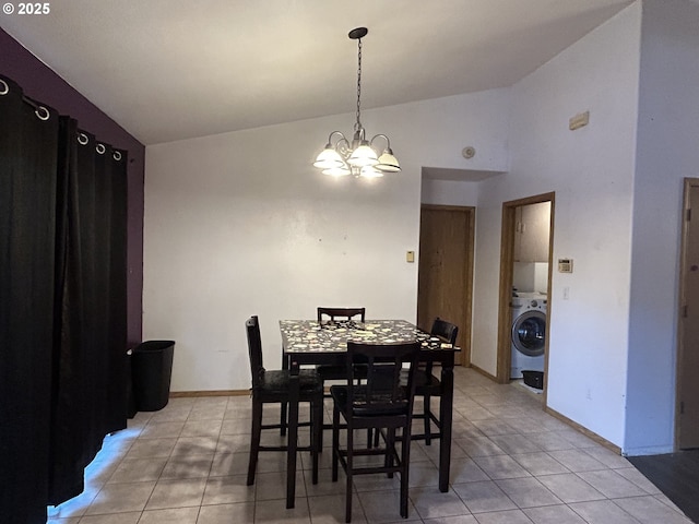 dining area featuring washer / clothes dryer, lofted ceiling, a chandelier, light tile patterned floors, and baseboards