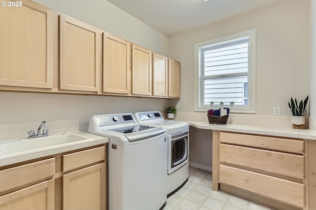 laundry area with light floors, a sink, cabinet space, and washer and clothes dryer