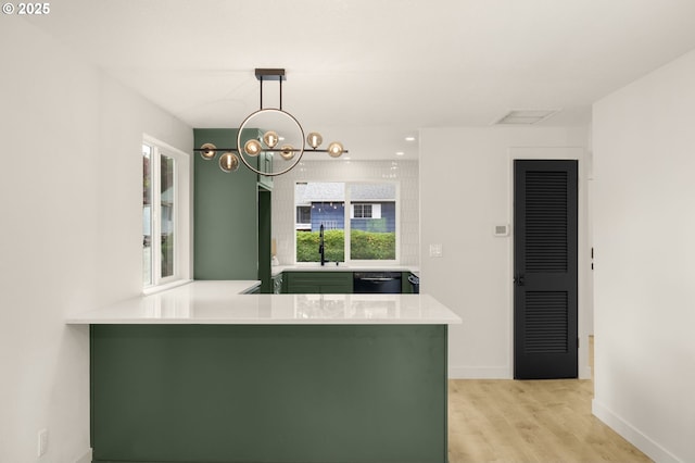 18090 NW Avalon Dr, Portland, OR 97229 - kitchen featuring green cabinets, light wood-style flooring, black dishwasher, a peninsula, and a chandelier