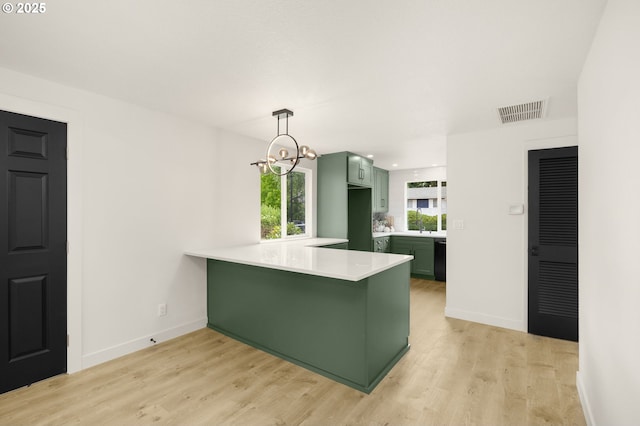 18090 NW Avalon Dr, Portland, OR 97229 - kitchen featuring green cabinetry, a peninsula, light countertops, light wood-style floors, and recessed lighting