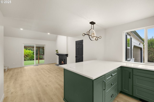 18090 NW Avalon Dr, Portland, OR 97229 - kitchen featuring green cabinetry, light countertops, light wood-type flooring, decorative light fixtures, and open floor plan