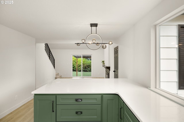 18090 NW Avalon Dr, Portland, OR 97229 - kitchen featuring green cabinets, a chandelier, light wood-style flooring, light countertops, and pendant lighting