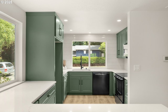 18090 NW Avalon Dr, Portland, OR 97229 - kitchen featuring green cabinetry, black appliances, light wood-style floors, light countertops, and recessed lighting